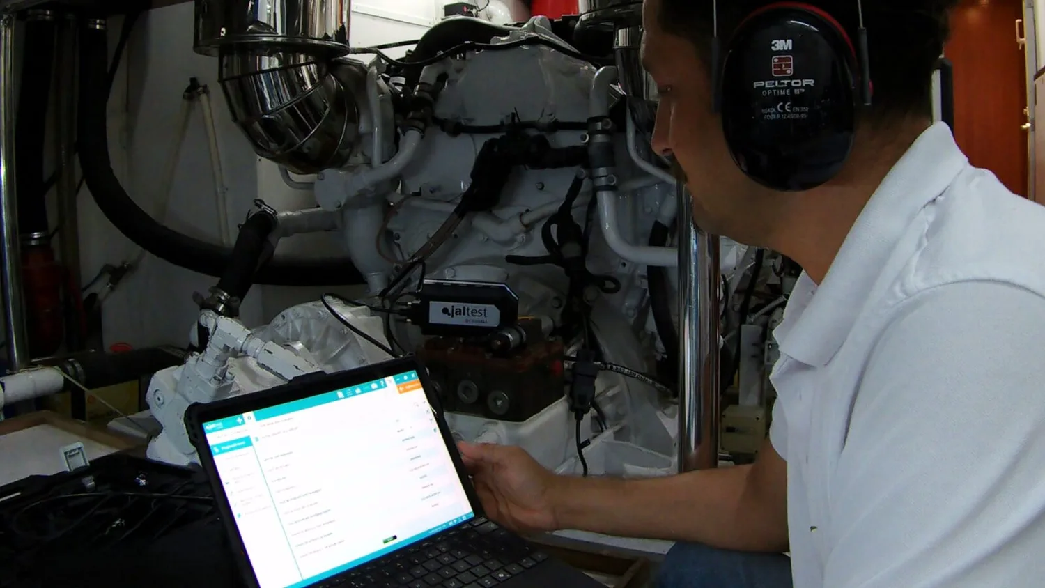 Motorun kumanda ünitesine bağlanmış diagnostik cihaz ve okuma yapılan dizüstü bilgisayar